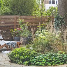 A garden with a sun lounger and garden borders
