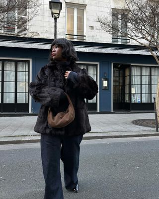 Influencer wears a brown suede bag.