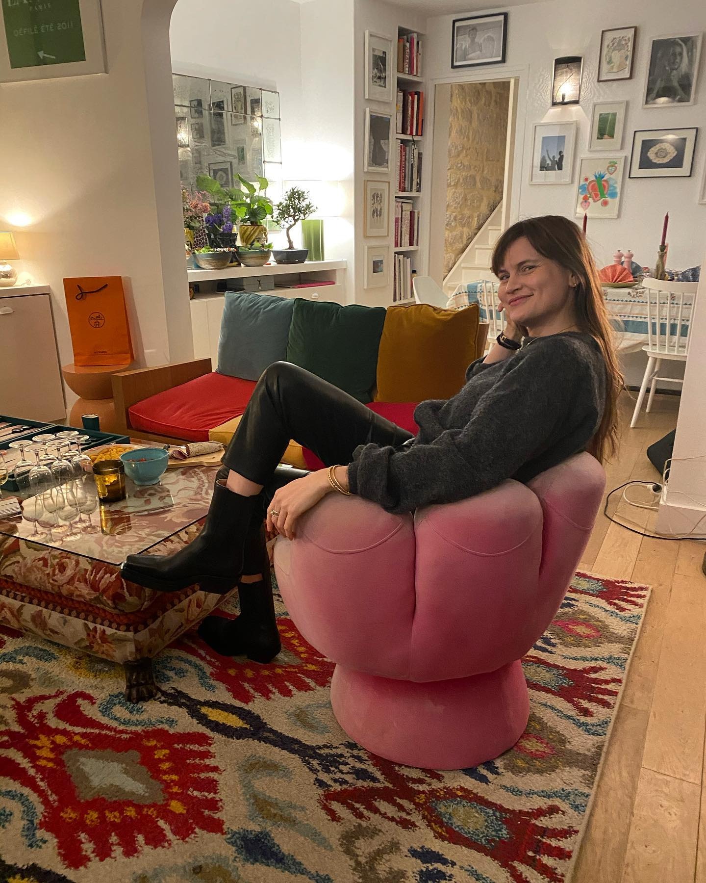 French editor and fashion creatie Eugenie Trochu poses in a pink chair at Alexandra van Houtte&amp;rsquo;s countryside apartment wearing leather pants and black Bottega Veneta boots