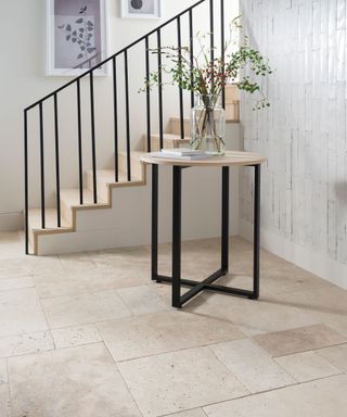 Natural travertine floor tiles in modern hallway with black iron small wood topped table