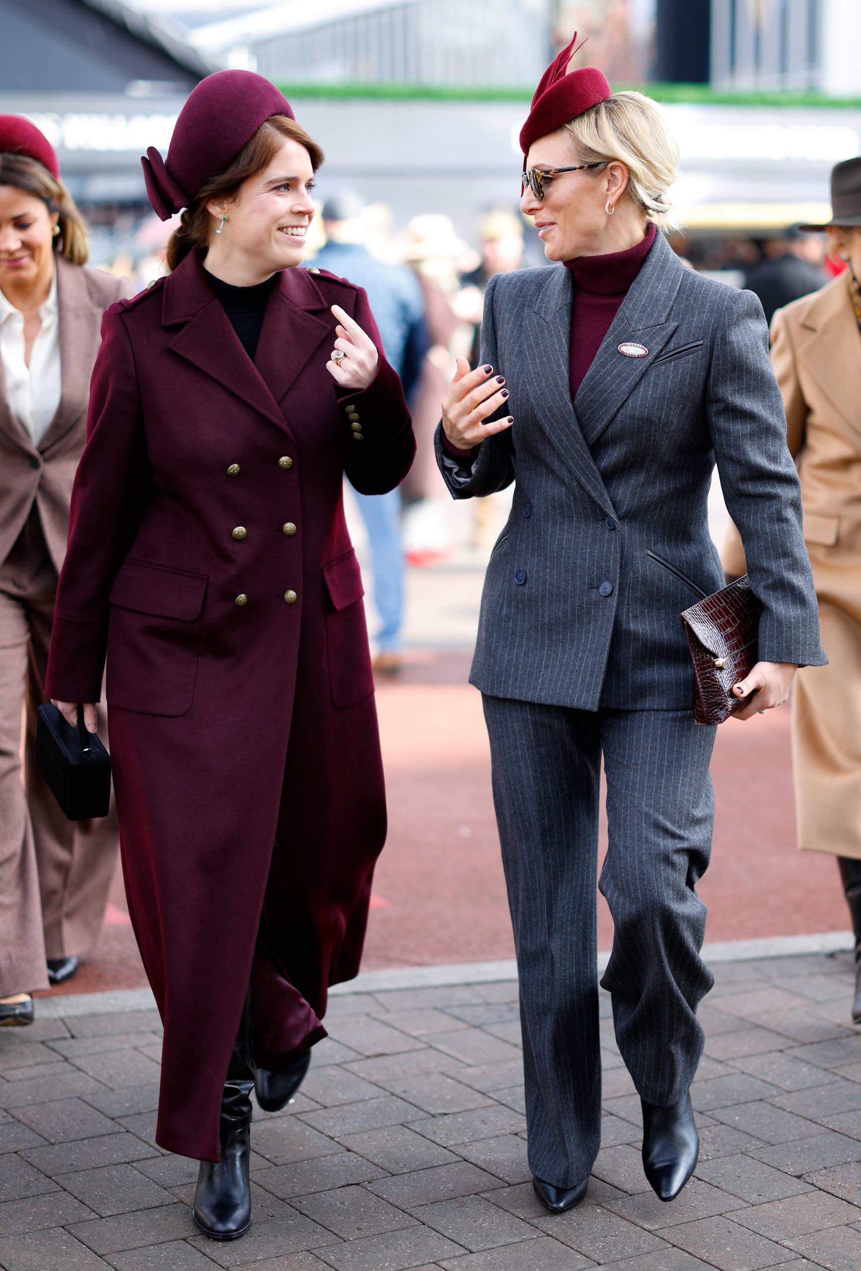 Zara Tindall walking with Princess Eugenie in burgundy outfits