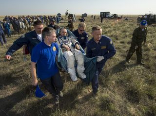Soyuz commander Mikhail Tyurin, a Roscosmos cosmonaut, is carried in a chair to a medical tent just after returning to Earth on May 14, 2014.