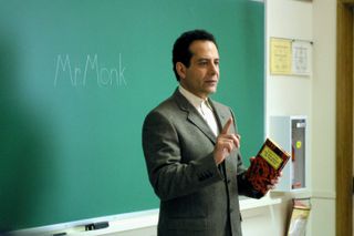 Tony Shalhoub as adrien monk speaking in front of a chalk board in a still from the show monk