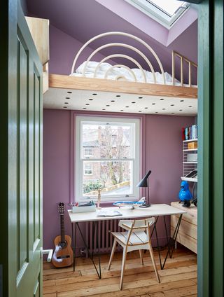 a lilac kids room with a loft bed and rooflight