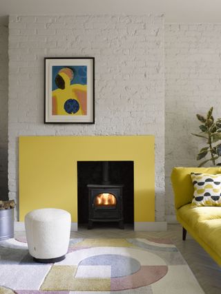 A living room with a modern asymmetrical fire surround painted yellow
