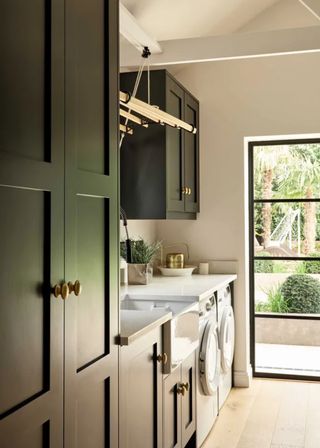 dark green utility room with Belgian doors and a large window going looking out toward the garden.