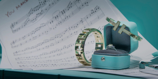 Two Tiffany bangles and a ring in a turquoise box on top of some sheet music