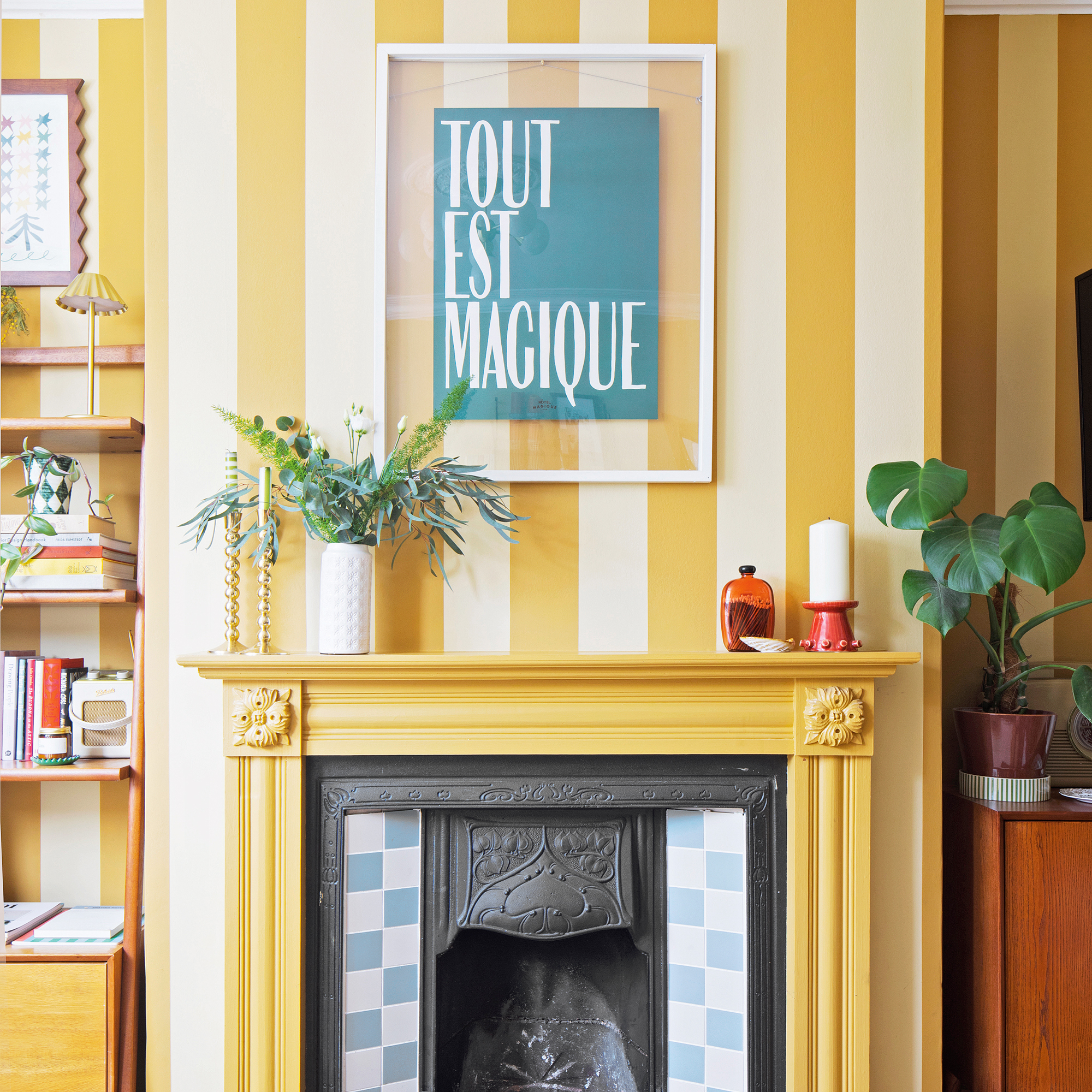 a living room with yellow and white striped wallpaper, a yellow painted fire surround and blue and white checked fireplace tiles