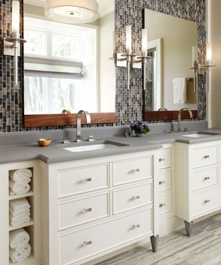 bathroom with cream cabinetry, limestone countertop and tiled wall