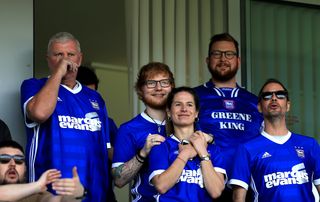 Ed Sheeran watches an Ipswich Town game with his fiance and future wife Cherry Seaborn in 2018.