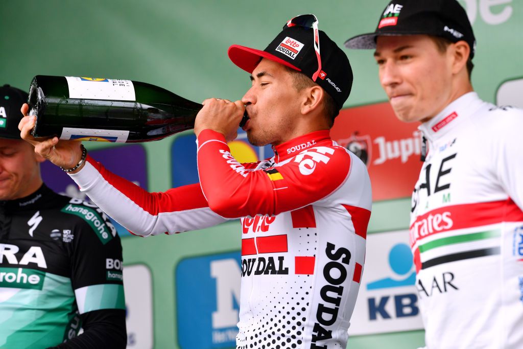 Caleb Ewan swigs the champagne on the podium