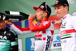 Caleb Ewan swigs the champagne on the podium