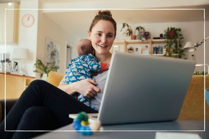 woman holding newborn baby while looking at a laptop