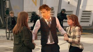 The 14th Doctor holding hands with Donna and Mel in his Doctor Who regeneration scene