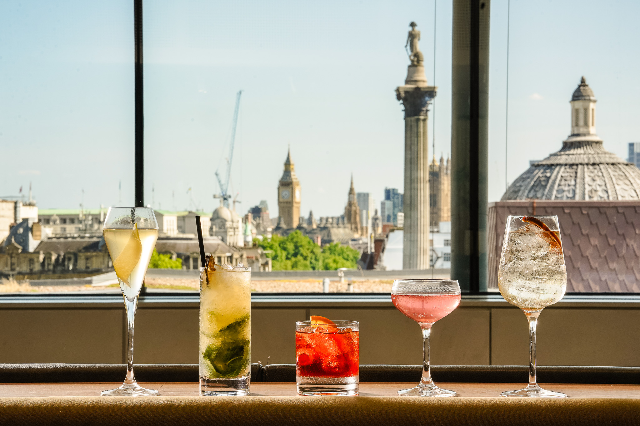 Five cocktails in front of window looking out onto Trafalgar Square