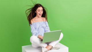 woman being blown away at the speed of her laptop