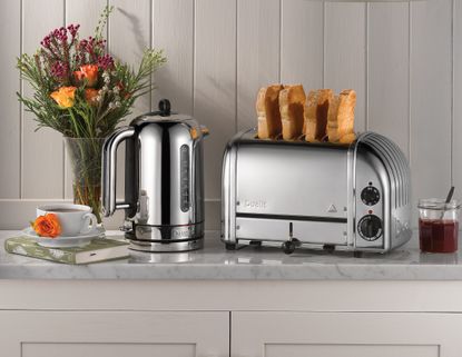 A chrome toaster and kettle on a marble kitchen countertop