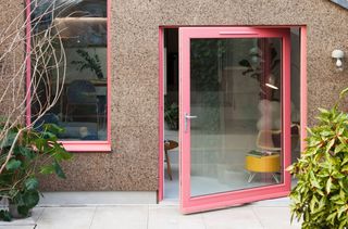 a pivot door in a RAL coral colour