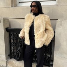 Marilyn wears a short white fur coat. 