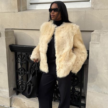 Marilyn wears a short white fur coat.