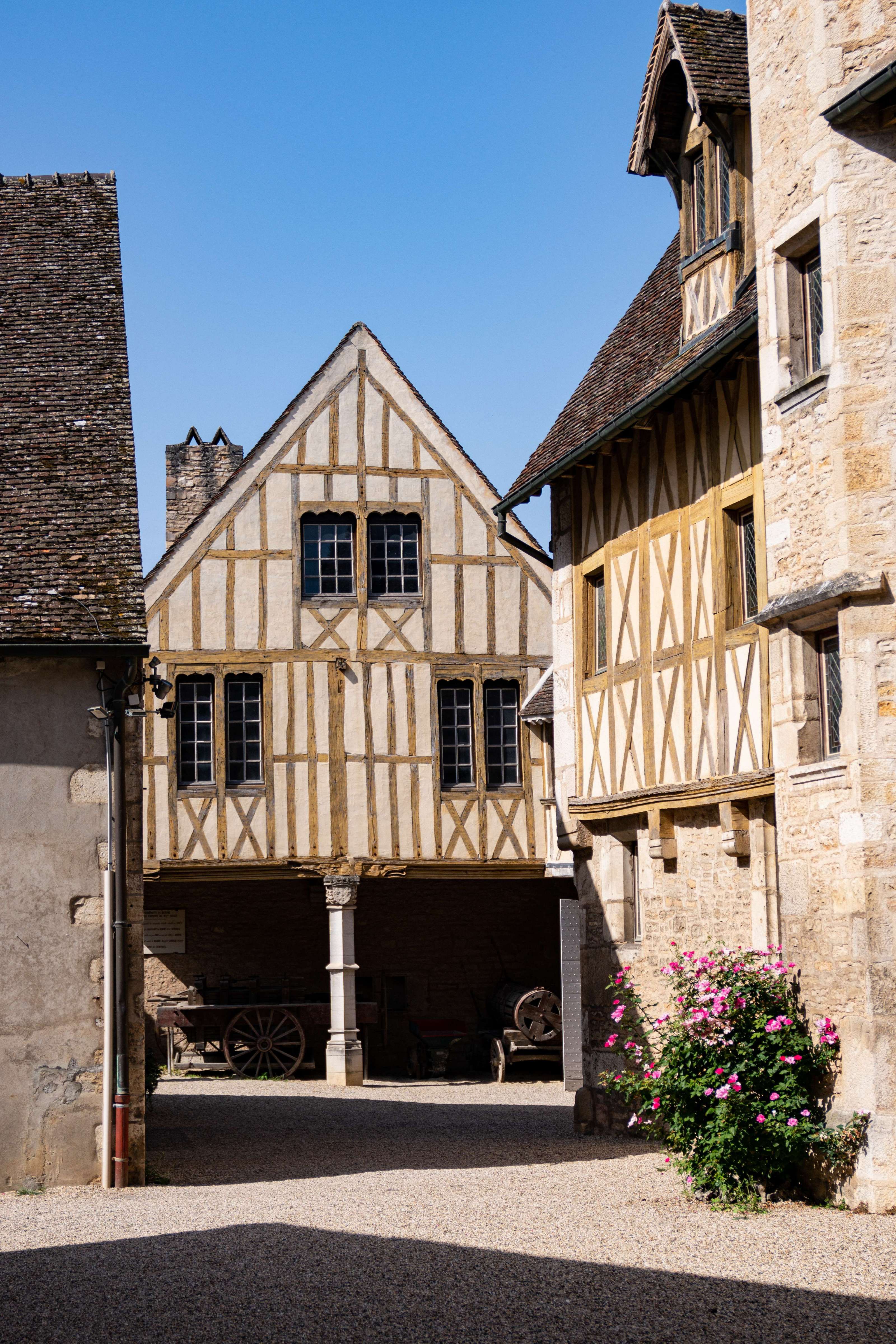 A series of images showing the history-inspired interiors of a rustic French chateau alongside outdoor, sunlit shots of buildings and the countryside.