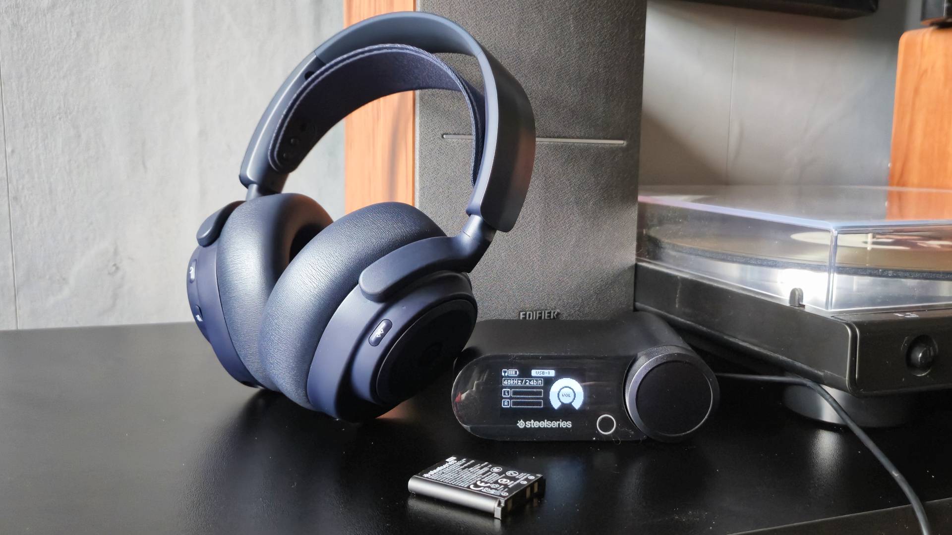 Photo of the SteelSeries Arctis Nova Pro Omni headset sitting next to the Game Hub.