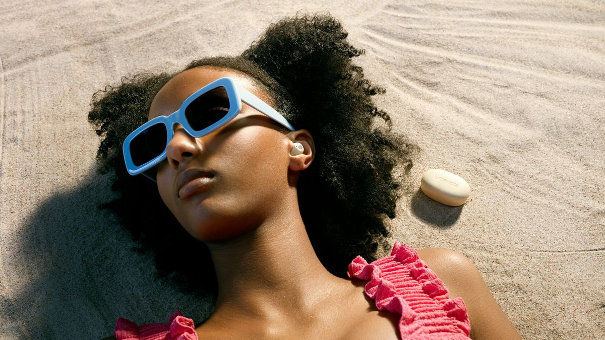 The Urbanista Earbuds being worn by a model at the beach