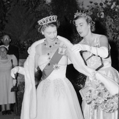 Lady Pamela Hicks helping Queen Elizabeth with her shawl