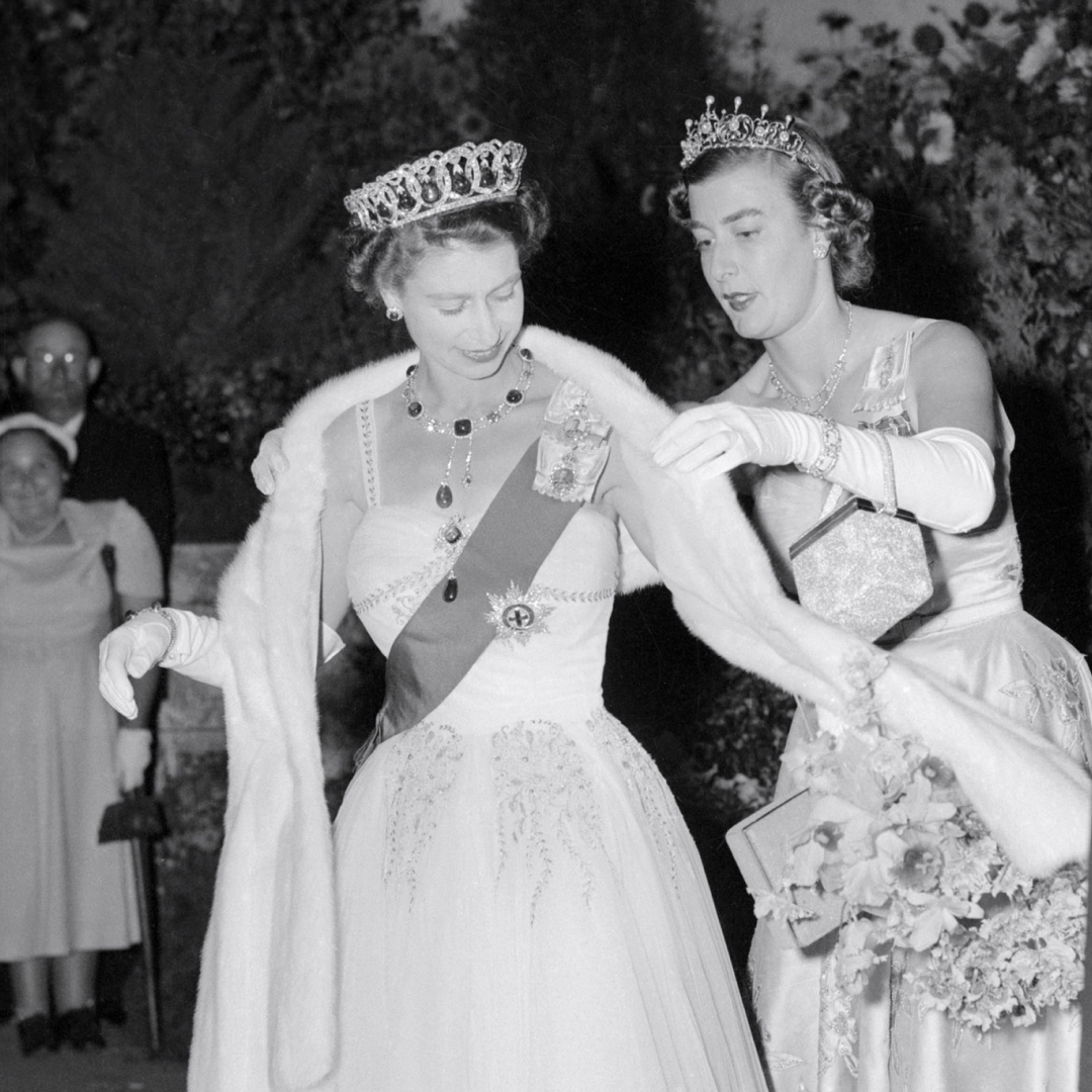 Lady Pamela Hicks helping Queen Elizabeth with her shawl