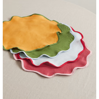 four colorful circular placemats with wavy edges 