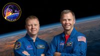 two men in blue flight suits pose for a portrait with the arms crossed in front of a background of earth as seen from space