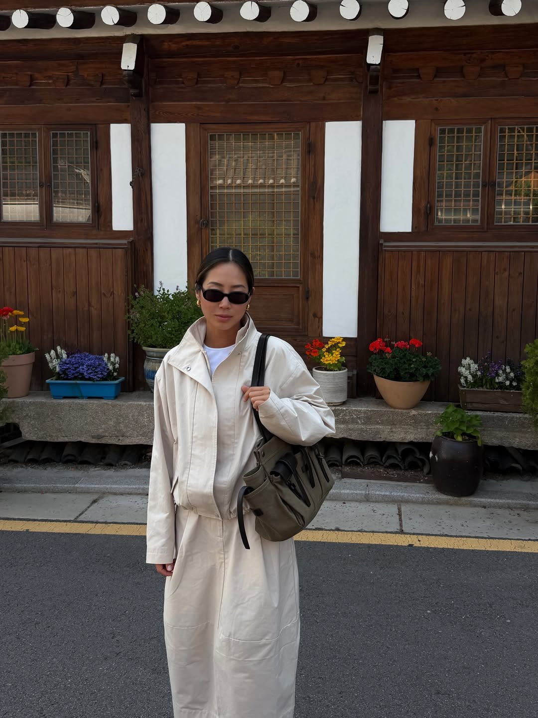 Woman wears canvas jacket, canvas skirt, carries Prada Route bag
