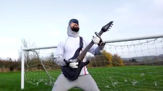A guitarist in a football goal