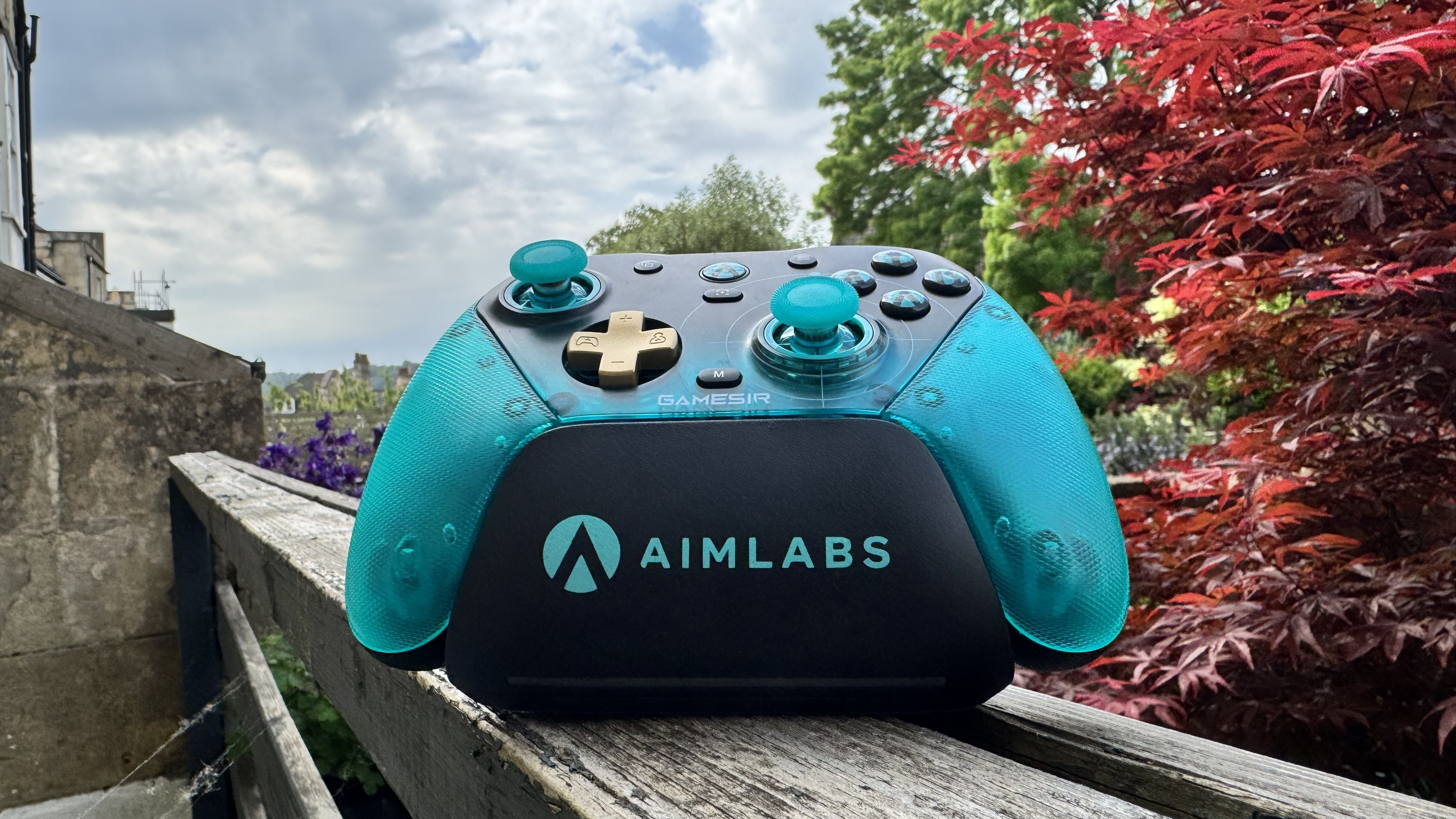 The GameSir G7 Pro 8K Aimlabs Edition on its dock on wood, outside