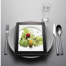 ipad with plate, silver ware, and water