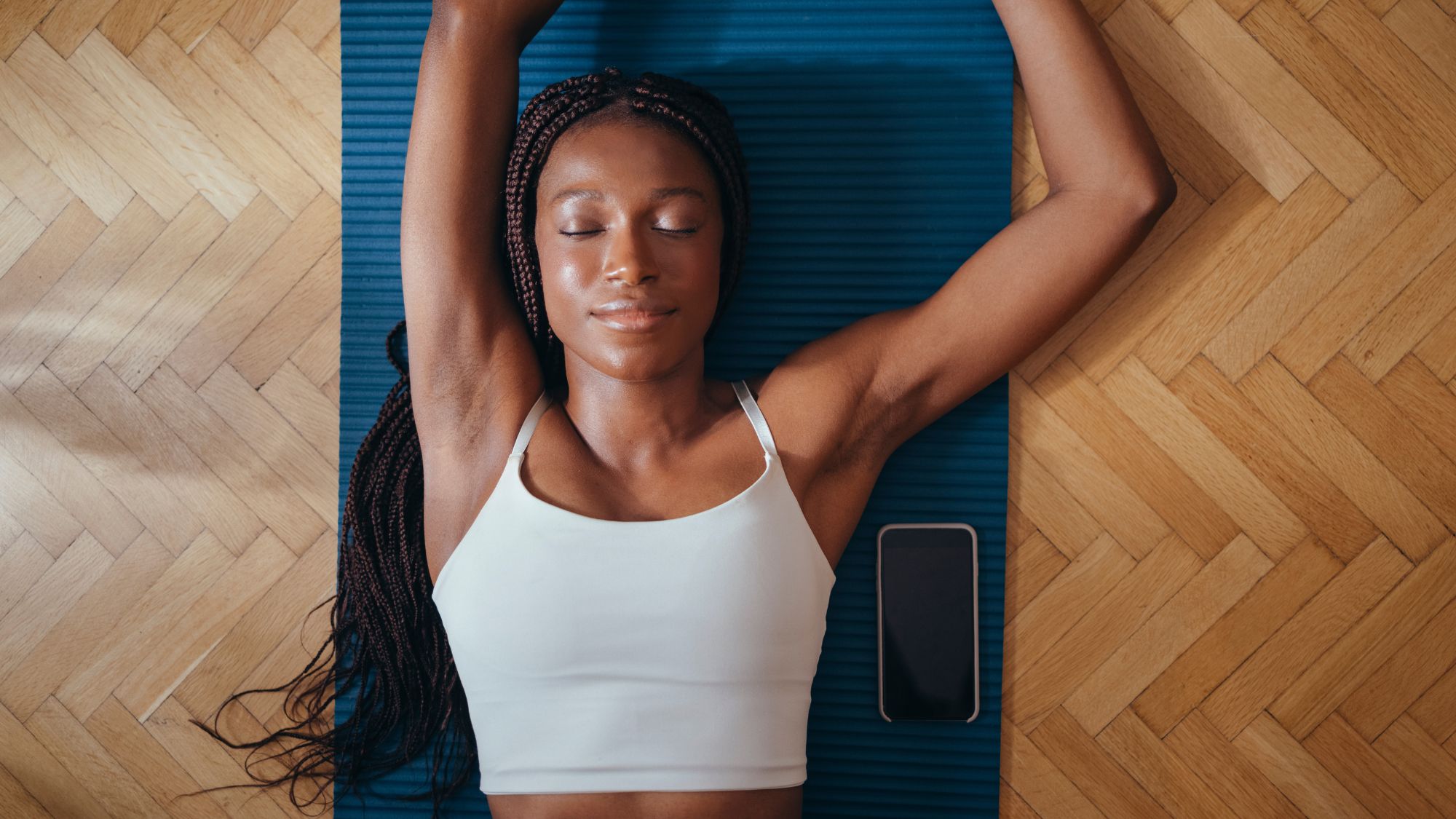 A woman stretching on a yoga mat on the floor