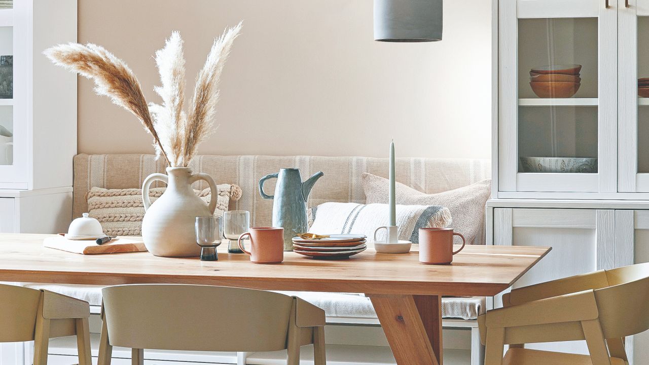 Wooden dining table and chairs, vase with dried flowers, dinnerware