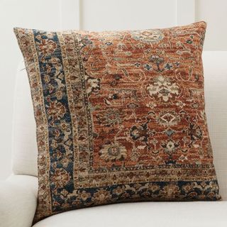 A Persian-style heirloom cushion cover in orange and blue tones