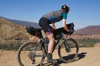 Image shows Anna riding on a gravel pass in Morocco with Ortlieb's bikepacking bags