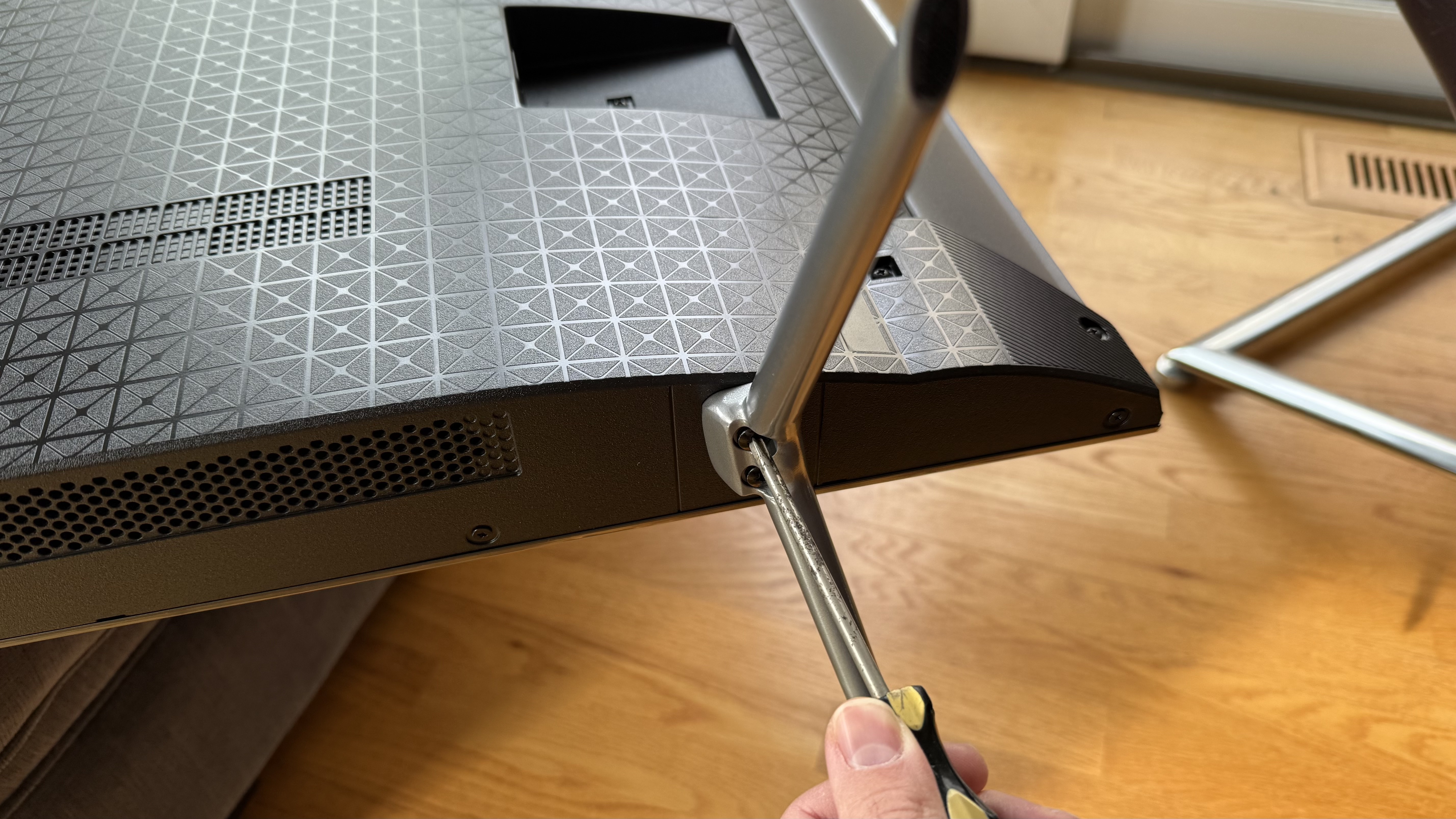 Amazon Fire TV Omni QLED (2025) support feet being attached with screwdriver