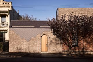 Exterior view including an arched doorway, of Nido house II in Melbourne Australia designed by Angelucci Architects