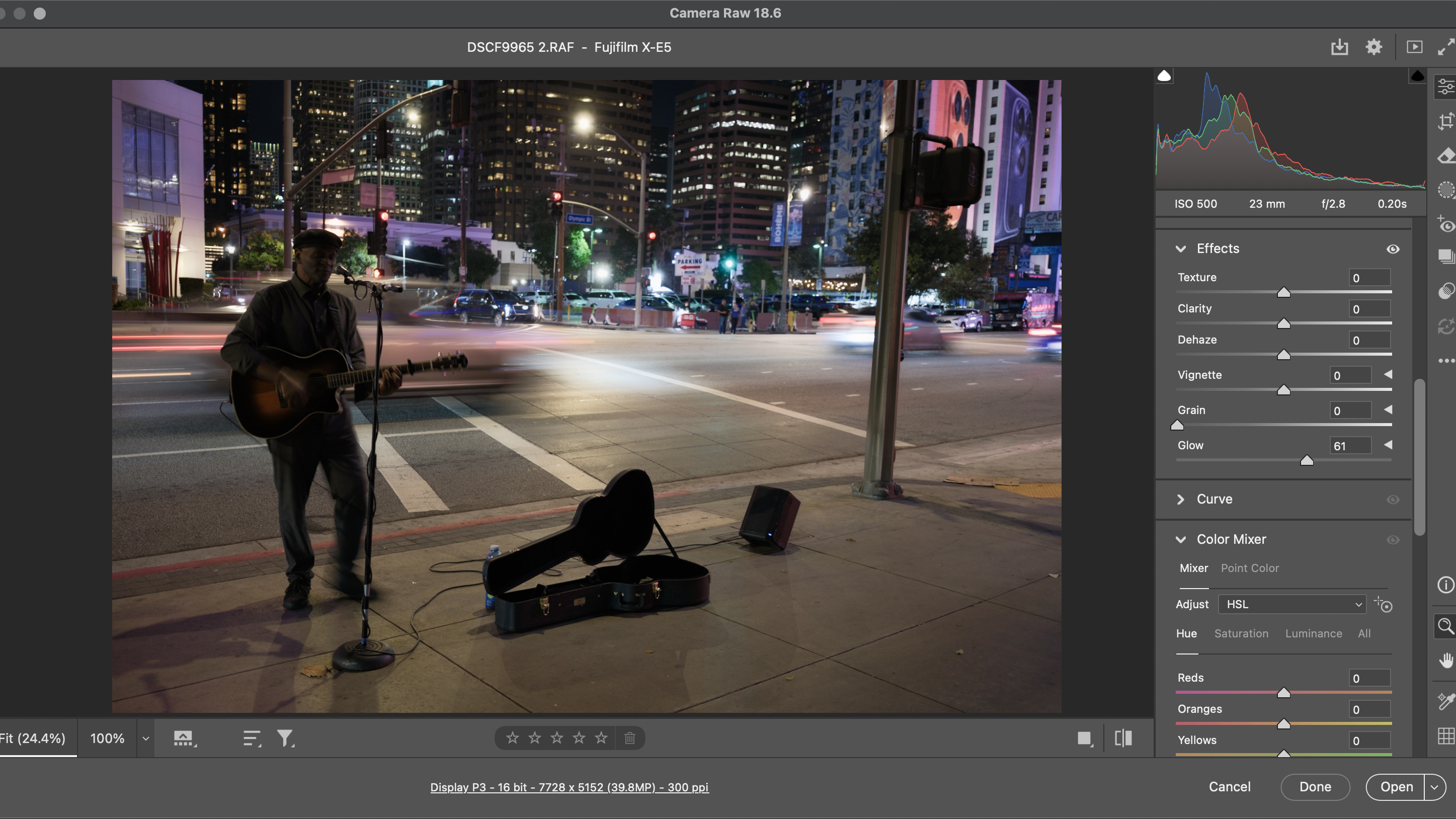 A street performer at night, with blurred traffic in the streets, edited in Adobe Camera RAW