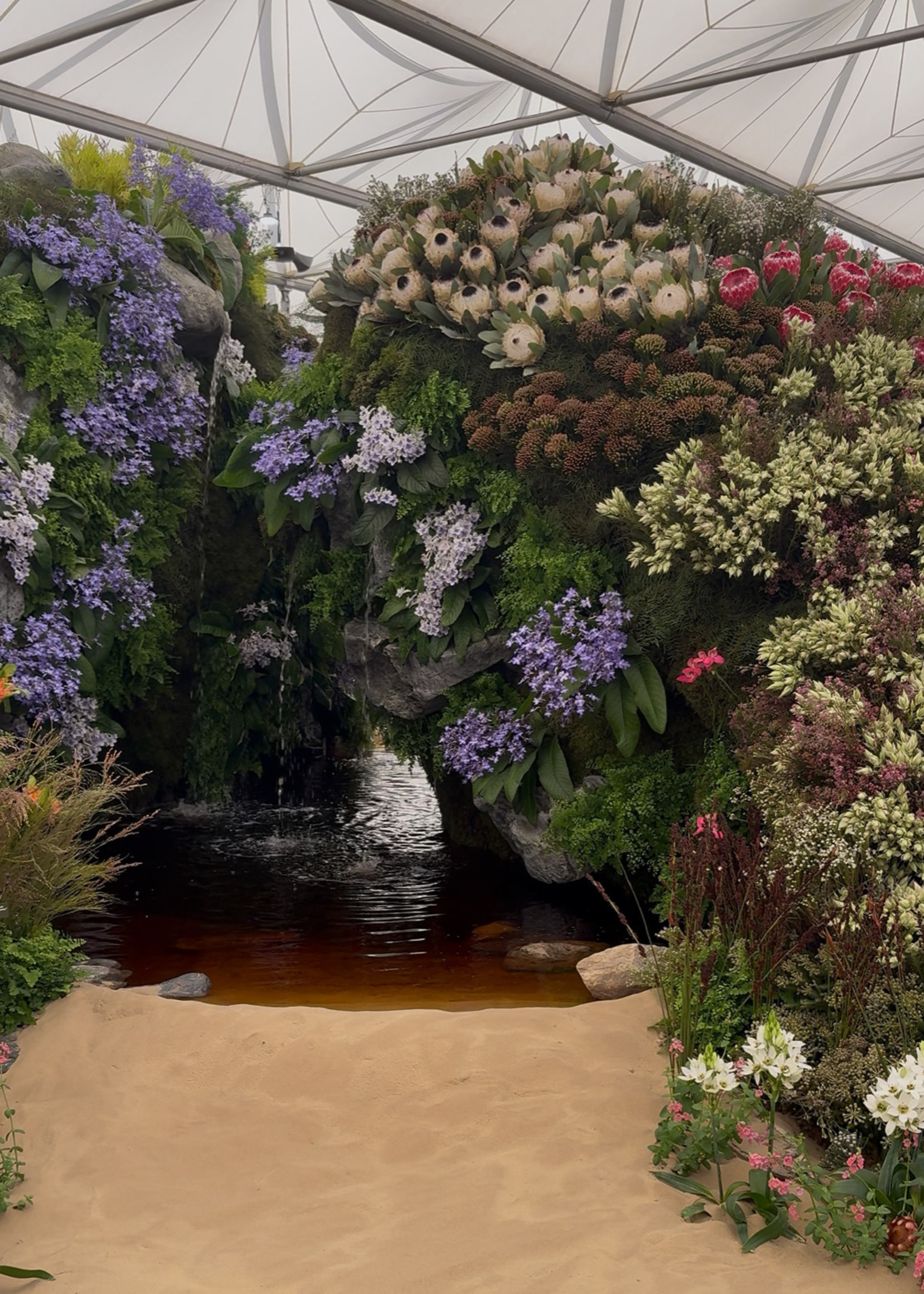 A colorful garden display with a waterfall feature at the Chelsea Flower Show 2025
