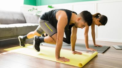 Two people doing mountain climbers at home