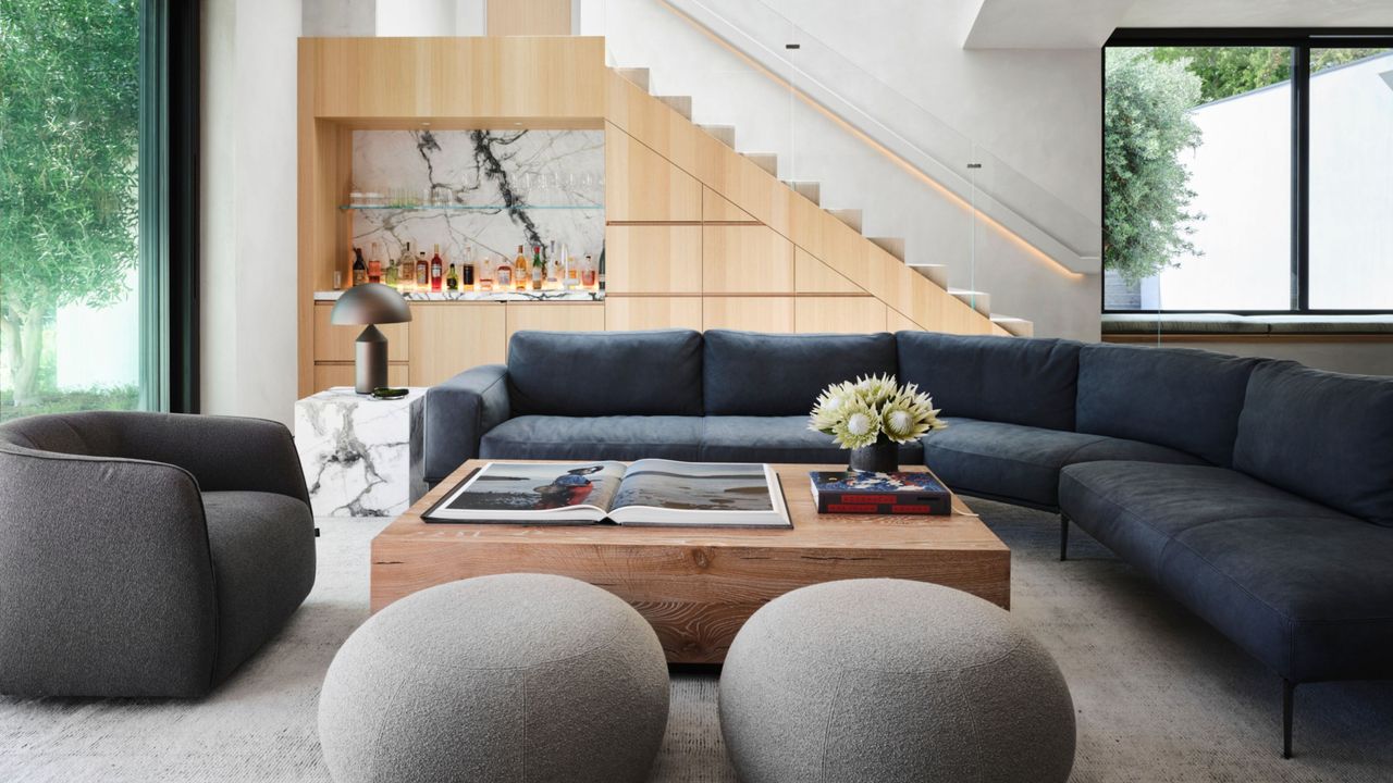 modern living room with sectional sofa, ottoman, and armchair with home bar in the background