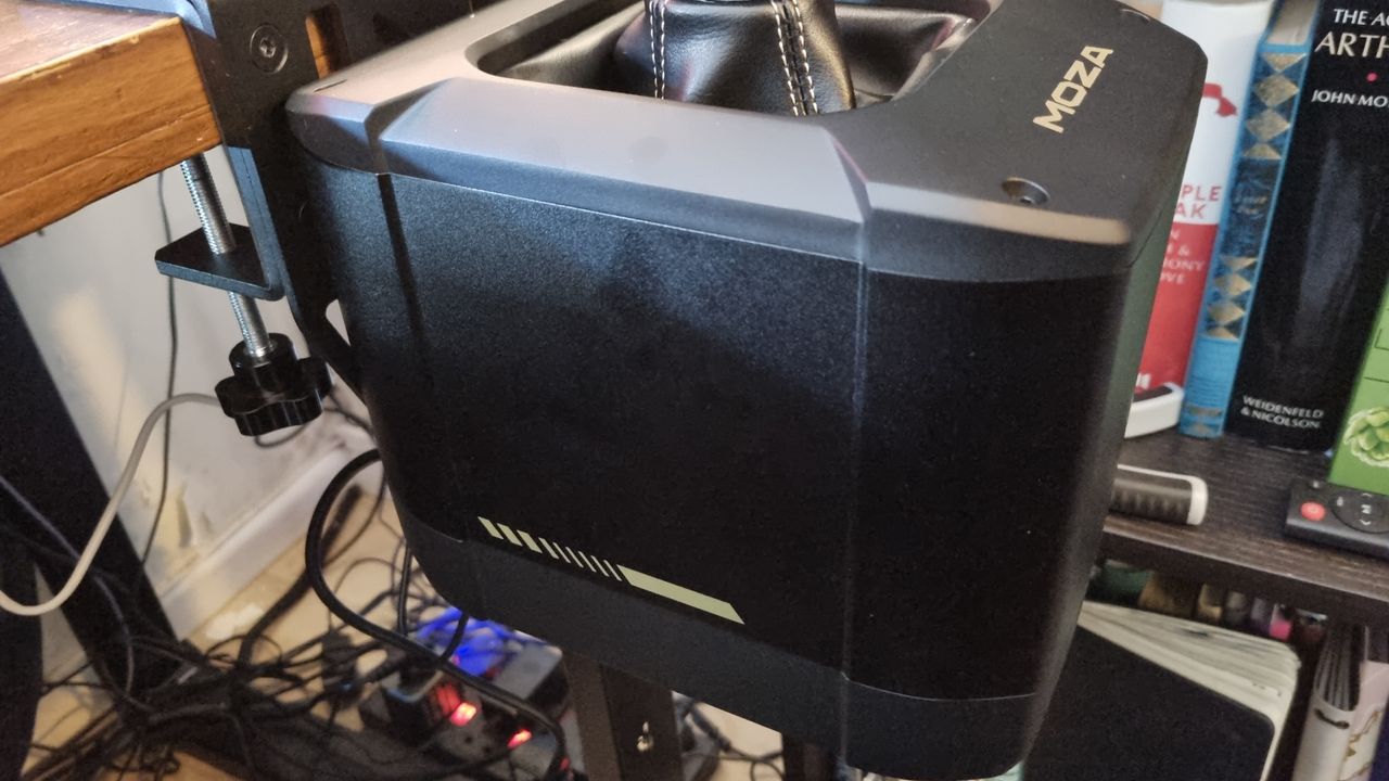A close up of the Moza AB9 FFB Base attached to a desk