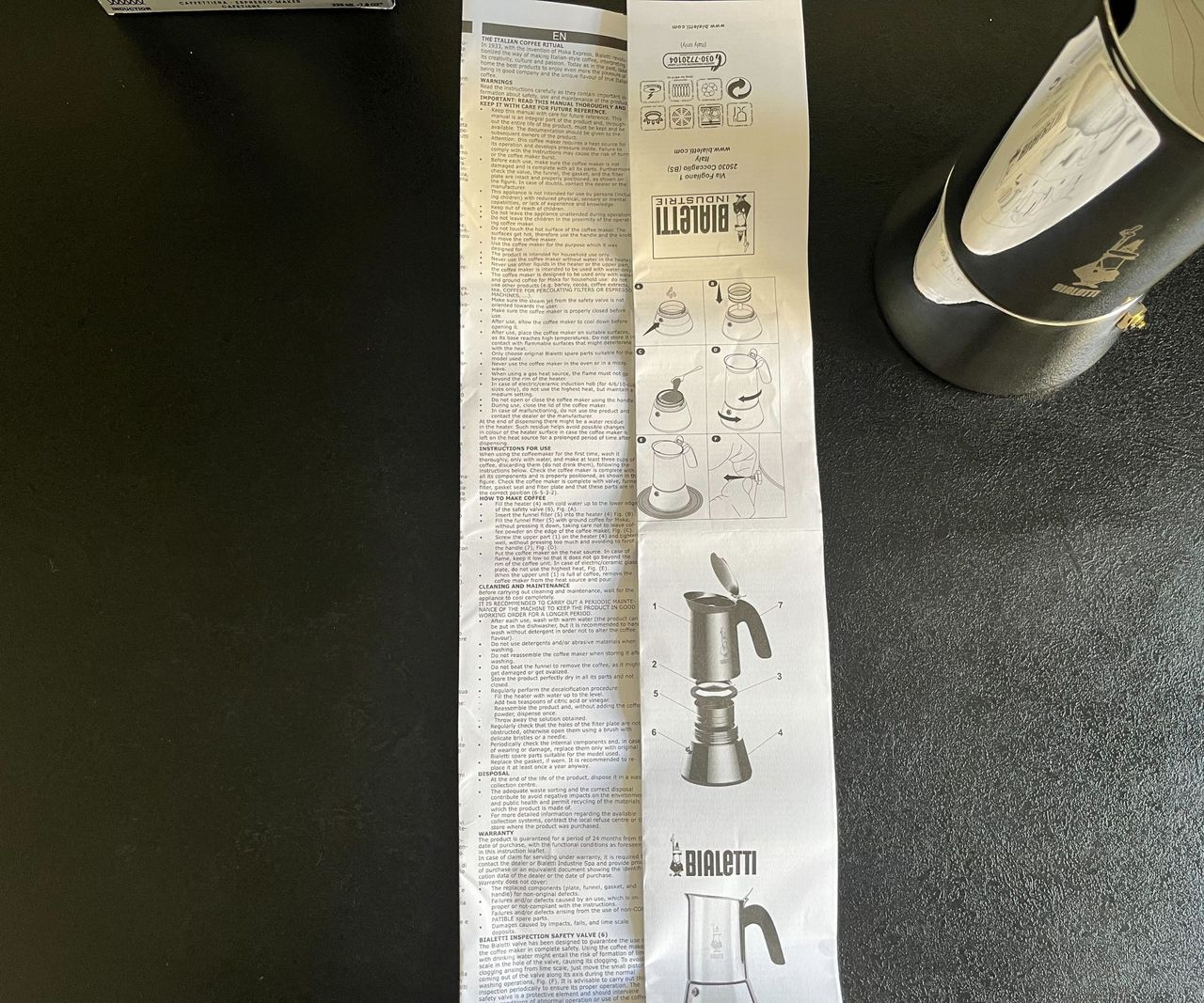 A folded Bialetti Venus instruction pamphlet putting the English instructions beside the diagrams, on a black counter