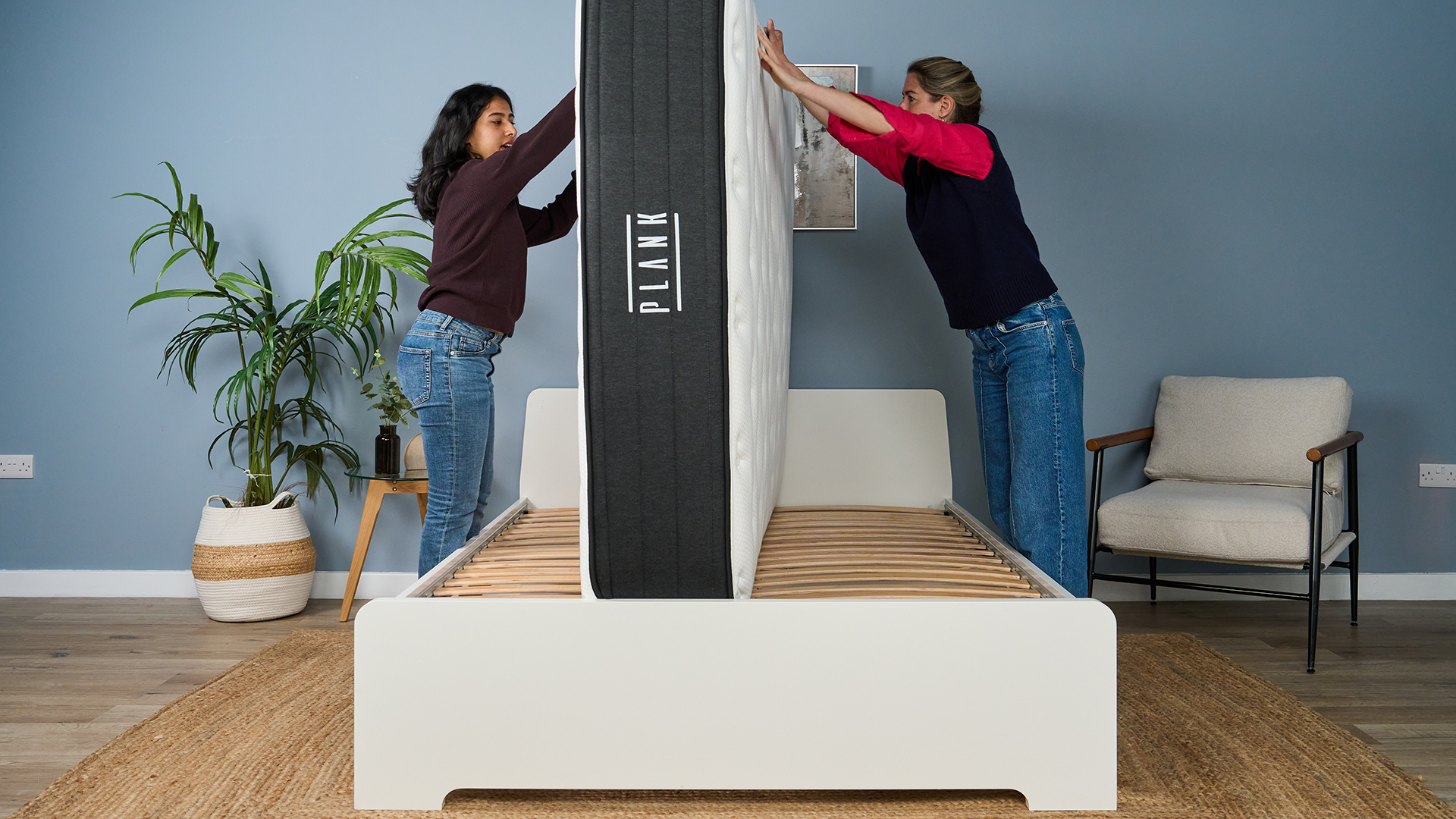 In our studio, mattress testers Becky George (left) and Nicola Appleton (right) flip the Plank Firm Luxe mattress on a bed frame