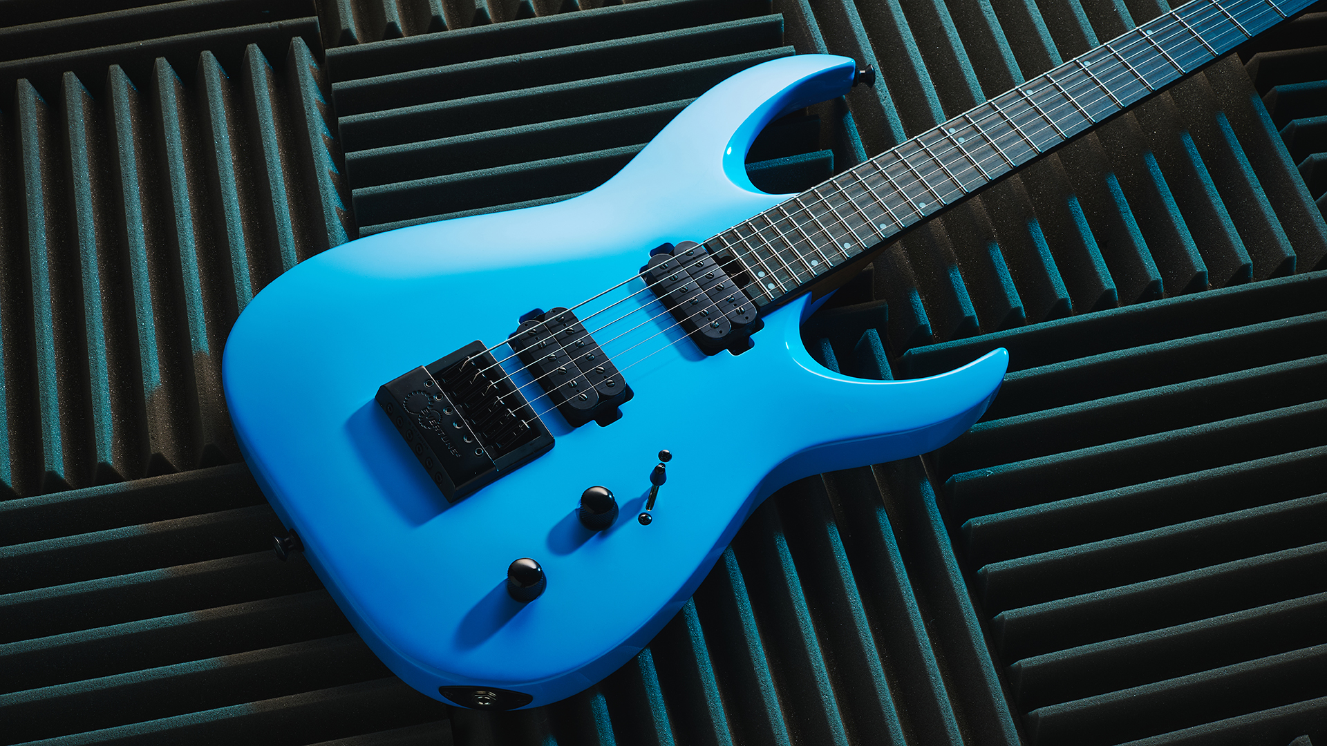 A Jackson Pro Plus Series Signature Misha Mansoor Juggernaut ET6 lying on some acoustic foam