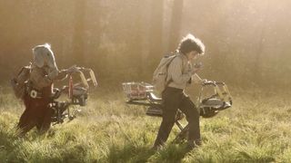 Neel (Robert Timothy Smith) and Wim (Ravi Cabot-Conyers) walking with their hover bikes in "Star Wars: Skeleton Crew"